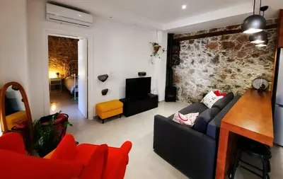 a living room with a couch and a tv at BELLE VUE Mountain Home in Kalopanayiotis