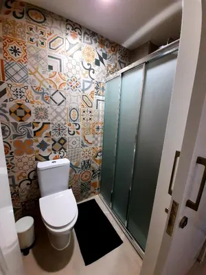 a bathroom with a toilet and tiles on the wall at BELLE VUE Mountain Home in Kalopanayiotis