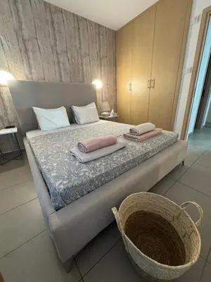 a bedroom with a bed with two towels and a basket at One-bedroom beach apartment, 30m from an amazing beach, Coralli in Protaras
