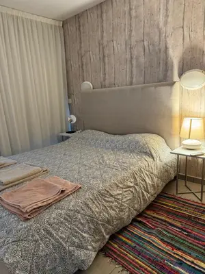 a bedroom with a bed with a blanket and a table at One-bedroom beach apartment, 30m from an amazing beach, Coralli in Protaras