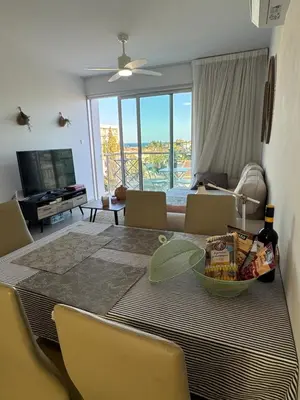 a living room with a table and chairs with a view at One-bedroom beach apartment, 30m from an amazing beach, Coralli in Protaras