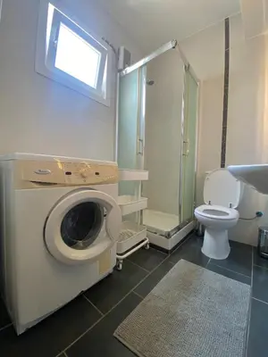 a bathroom with a washing machine and a toilet at Aphrodite Sea View Apartment in Larnaka