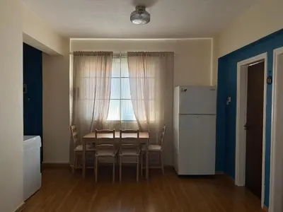 a dining room with a table and chairs and a window at Aphrodite Sea View Apartment in Larnaka