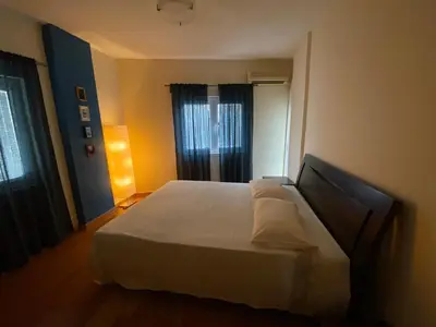 a bedroom with a large white bed and a window at Aphrodite Sea View Apartment in Larnaka