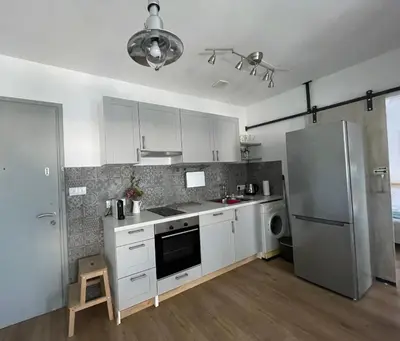 a kitchen with white cabinets and a stainless steel refrigerator at Lovely 1-bd apt with patio in Nicosia center in Nicosia