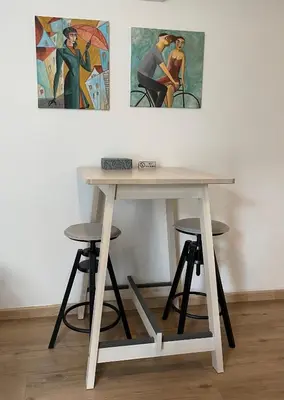 a wooden table with two stools and two paintings at Lovely 1-bd apt with patio in Nicosia center in Nicosia