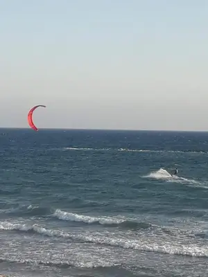 a person is kite surfing in the ocean at SEAFRONT BEACH PARTY VILLA in Pervolia