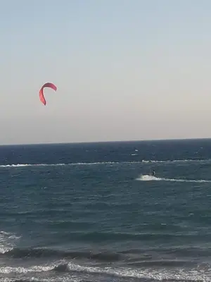 a person is kite surfing in the ocean at SEAFRONT BEACH PARTY VILLA in Pervolia
