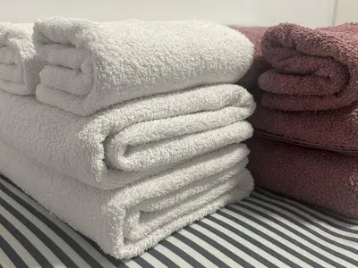 a pile of white towels sitting on top of a bed at Olymbos Garden Apartment IV in Ayia Napa