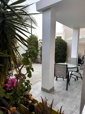 a patio with plants and a table and chairs at Olymbos Garden Apartment IV in Ayia Napa