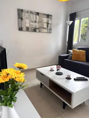 a living room with a couch and a coffee table at Olymbos Garden Apartment IV in Ayia Napa