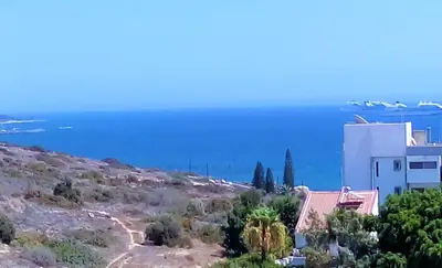 a house on a hill with the ocean in the background at 1 bedroom apartment with a magnificent sea view in Limassol