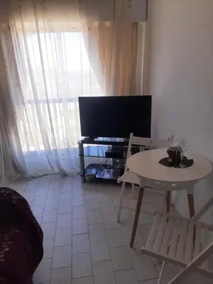 a living room with a table and a tv at 1 bedroom apartment with a magnificent sea view in Limassol