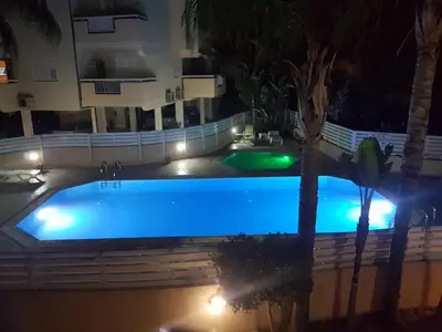 a large swimming pool at night with lights at Panorama Village Complex in Paralimni
