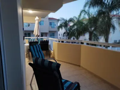 a balcony with chairs and an umbrella on a balcony at Panorama Village Complex in Paralimni