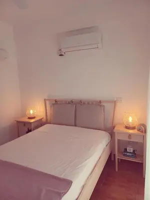a bedroom with a bed with two lamps on tables at Protaras sea view Villa with private pool in Protaras