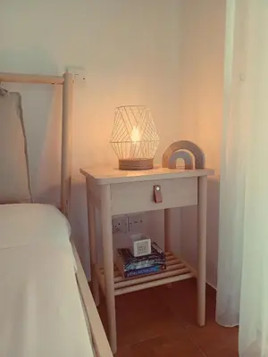 a table with a lamp on it next to a bed at Protaras sea view Villa with private pool in Protaras