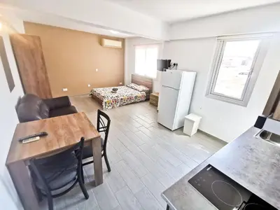 a small living room with a table and a kitchen at Hidden Gem City Studio in Larnaka