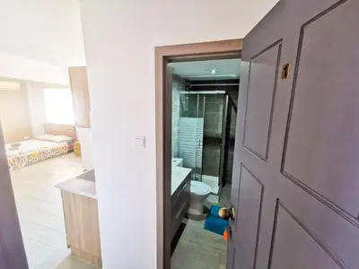 a door to a bathroom with a toilet and a sink at Hidden Gem City Studio in Larnaka