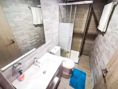 a bathroom with a sink and a toilet and a mirror at Hidden Gem City Studio in Larnaka