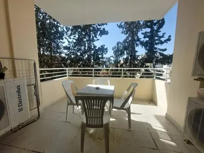 a patio with a table and chairs on a balcony at Sunny 2 Bedroom Larnaca Center in Larnaka