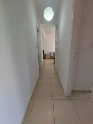 a hallway with a white wall and a light on the ceiling at Sunny 2 Bedroom Larnaca Center in Larnaka