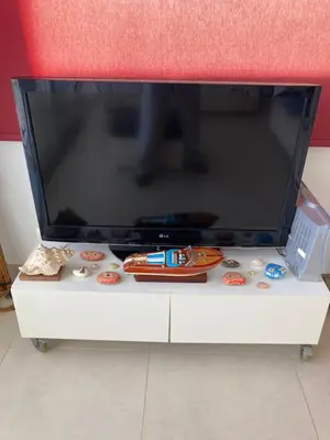 a flat screen tv sitting on top of a white cabinet at Trident Beach Apartment in Protaras