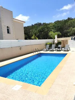 a swimming pool with chairs next to a building at Villa Alba, Luxury 4 BDRM Villa with Heated Pool in Protaras
