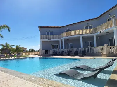 a swimming pool in front of a house at Grand villa Lynn seaview Ayia Napa in Ayia Napa