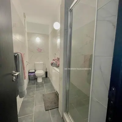 a bathroom with a toilet and a glass shower door at Mad beach in Protaras