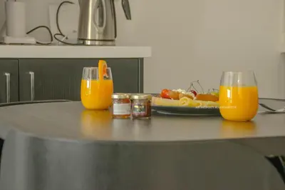 two glasses of orange juice on a table with a plate of food at Mad beach in Protaras