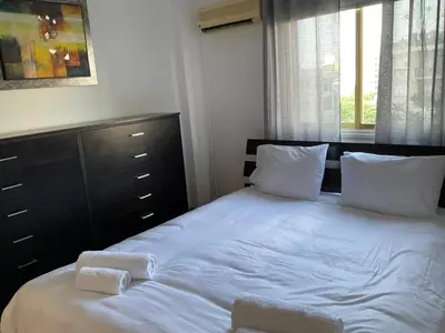 a bedroom with a bed with white sheets and pillows at StayCity Flat!!! in Nicosia