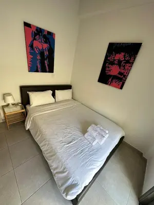 a bed in a bedroom with two pictures on the wall at Modern City Center Apartment Saripolou 2 in Limassol