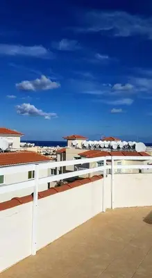 a white building with a view of the ocean at Armstrong Apartment in Paralimni