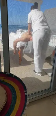 a man standing in front of a window looking at a woman at Pampering Beach Dream, A Stunning Luxury Retreat at Yialos Village in Meneou