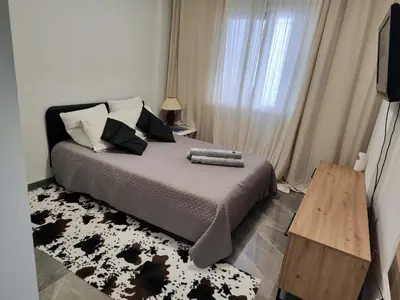 a bedroom with a bed with a television and a table at Pampering Beach Dream, A Stunning Luxury Retreat at Yialos Village in Meneou