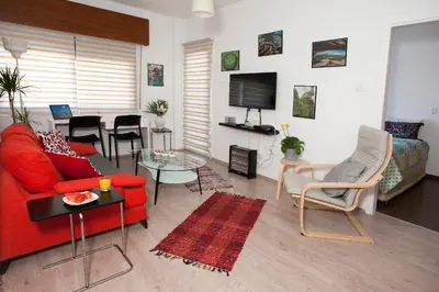 a living room with a red couch and a table at ARTEMIS 3, Beachfront Boutique Apartment in Limassol