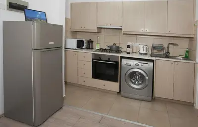 a kitchen with a refrigerator and a washing machine at ARTEMIS 3, Beachfront Boutique Apartment in Limassol