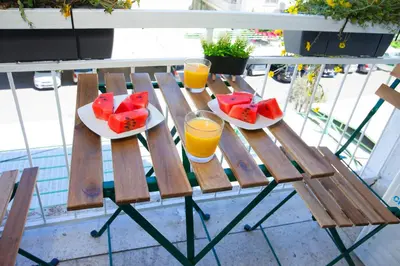 a wooden table with two glasses of orange juice and fruit at ARTEMIS 3, Beachfront Boutique Apartment in Limassol