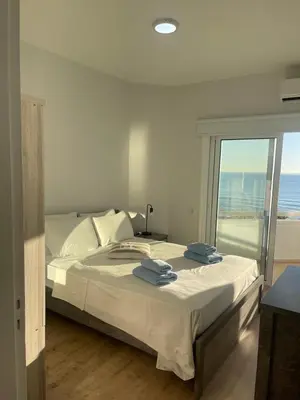 a bedroom with a bed with a view of the ocean at Alex Beach Apartment 34 in Larnaka