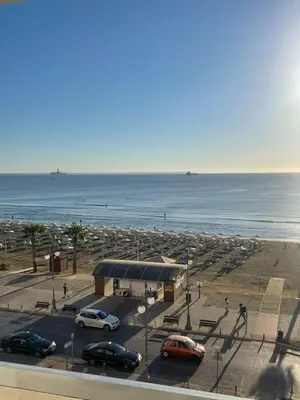 a parking lot with cars parked next to the ocean at Alex Beach Apartment 34 in Larnaka