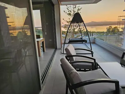 a balcony with chairs and a view of the ocean at Majestic Sunset Salt Lake Views 300m from beach in Larnaka