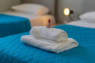 a pile of towels sitting on top of a bed at Majestic Sunset Salt Lake Views 300m from beach in Larnaka