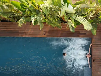 a pool with two people swimming in the water at Lora Pearl Luxury Villa in Protaras