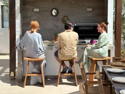 a group of people sitting at a kitchen counter at Lora Pearl Luxury Villa in Protaras