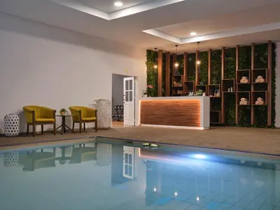 a swimming pool in a house with chairs and a table at Atlantica Sungarden Park in Ayia Napa