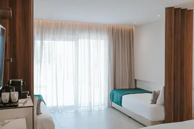 a hotel room with a bed and a large window at Atlantica Sungarden Park in Ayia Napa