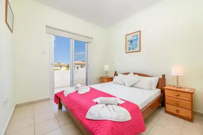 a bedroom with a bed and a large window at Villa Alexander in Protaras