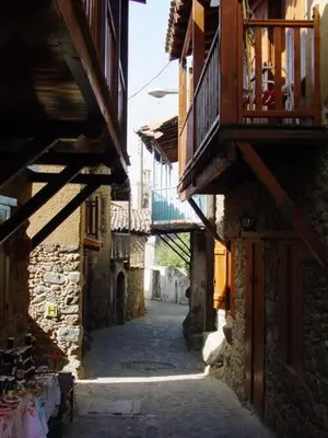 an alley with buildings and a balcony on a building at The Mill Hotel in Kakopetria
