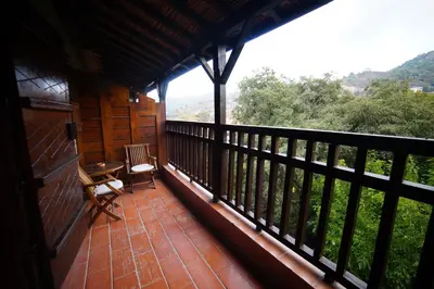 a balcony of a cabin with a table and chairs at The Mill Hotel in Kakopetria